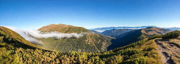 Panoramic shot of autumn valleys and mountains under blue sky - Low Tatras National park, Slovakia, Europe