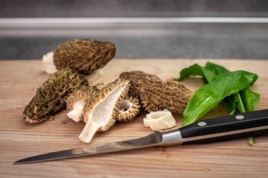 Ahşap tahta üzerinde Morel mantar ve yabani sarımsak dilimleri