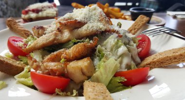 Sezar salatası beyaz tabakta, kırpılmış görünümü.