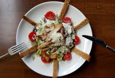 Sezar salatası beyaz tabakta, kırpılmış görünümü.