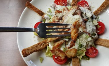 Sezar salatası beyaz tabakta, kırpılmış görünümü.