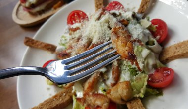 Sezar salatası beyaz tabakta, kırpılmış görünümü.