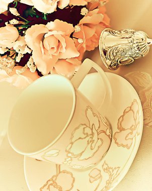 Plaka üzerinde çay bardağı ile masaya çiçek