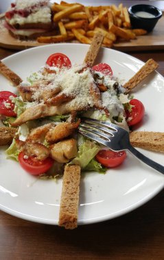 Sezar salatası beyaz tabakta, kırpılmış görünümü.