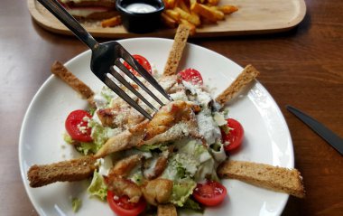 Sezar salatası beyaz tabakta, kırpılmış görünümü.