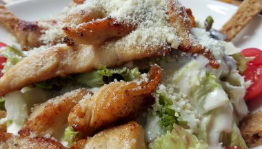 Sezar salatası beyaz tabakta, kırpılmış görünümü.