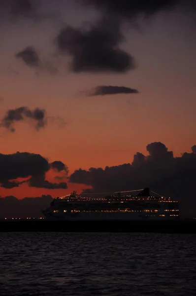 Sunset at seaside with boats silhouettes