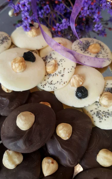 Glazed cookies with hazelnuts and poppy seeds serving with violet flowers