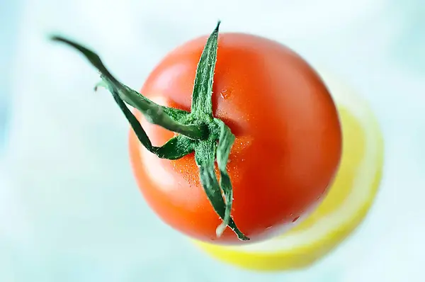 Tomate Maduro Con Medio Limón Sobre Fondo Azul Con Espacio — Foto de Stock