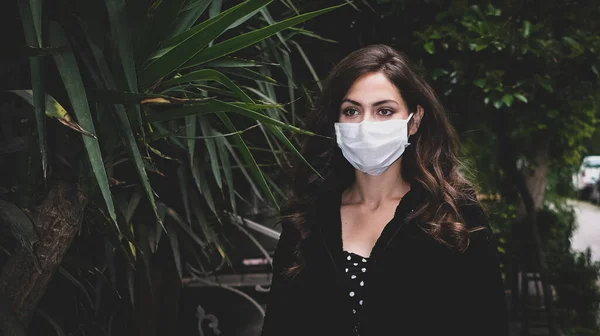 Sokaktaki Coronavirus 'u korumak için tıbbi maske takan genç bir kadın.