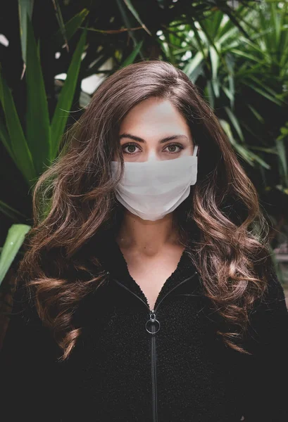 Sokaktaki Coronavirus 'u korumak için tıbbi maske takan genç bir kadın.