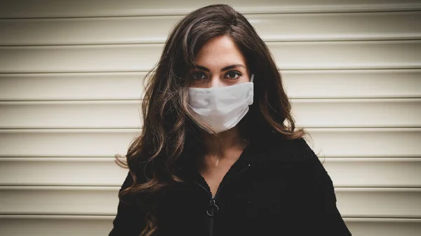 Sokaktaki Coronavirus 'u korumak için tıbbi maske takan genç bir kadın.