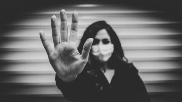 通りにコロナウイルスを保護するために医療マスクを身に着けている若い女性は彼女の手で停止と言っ — ストック写真
