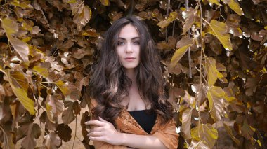 Güz yapraklarında poz veren güzel manken.