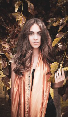 Güz yapraklarında poz veren güzel manken.