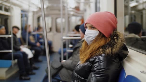 Žena v lékařské masce obličeje jezdí v metru, ochrana proti koronaviru — Stock video