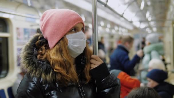 Vrouw met medisch gezichtsmasker rijdt in de metro, bescherming tegen coronavirus — Stockvideo