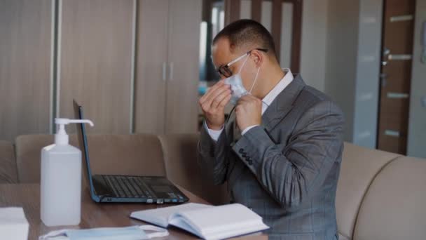 Employé de bureau portant un masque médical travaille à distance à la maison, désinfecte les mains — Video