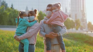 Coronavirüs salgını sırasında şehir sokaklarında gezen maskeli aile.