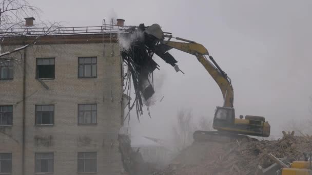 Excavatorul demolează clădirea veche, brațul hidraulic al excavatorului se sparge în acoperiș — Videoclip de stoc