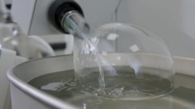 Kimya laboratuvarında dönen vakum buharlaştırıcısı. Cam ampul sıvı içinde döner..