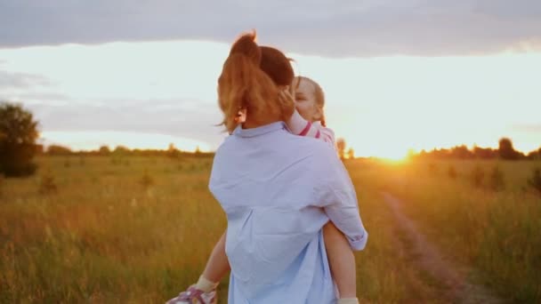 Mother holding cute daughter in arms, hugging each other, spinning and laughing — Stock Video