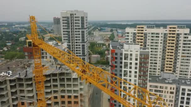 Vista aérea: guindaste grande torre funciona em canteiro de obras de construção de edifícios residenciais — Vídeo de Stock