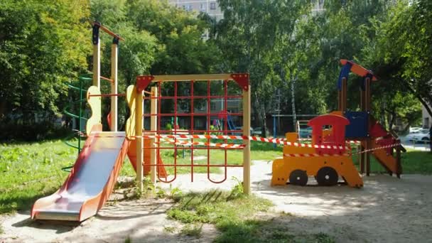 Parque infantil cerrado durante la cuarentena coronavirus, vallado con cinta roja prohibida — Vídeos de Stock