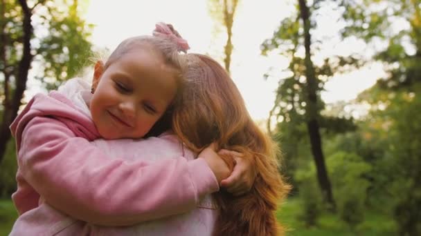 Kleine Tochter umarmt Mutter mit geschlossenen Augen, glückliche, liebevolle Familie — Stockvideo