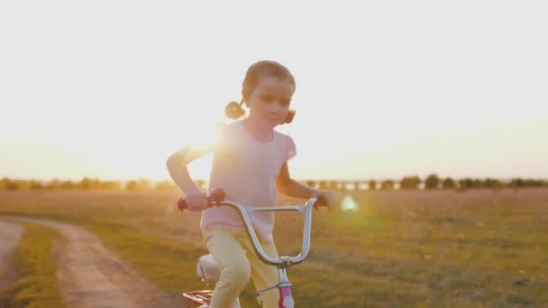 Glad leende flicka ridning cykel på landsbygden väg, ha kul utomhus — Stockvideo