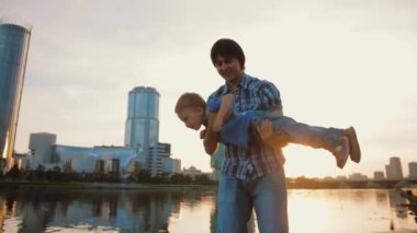 Mutlu baba daire çiziyor, çocuk uçarken gülümsüyor, çocuk babasıyla oynuyor.