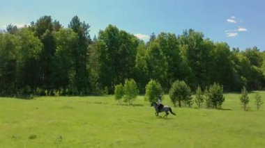 Hava: Yazın güneşli bir günde dört nala koşan atlı bir kadın.