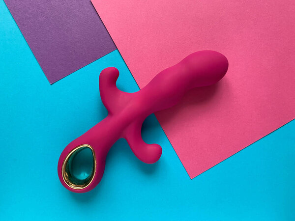 Sex toy. Pink vibrator on a colored background. Useful for adult, sex shop