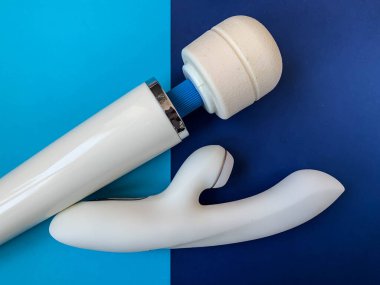 Seks oyuncakları. Mavi arka planda iki beyaz vibratör. Yetişkinler için kullanışlı, seks dükkanı