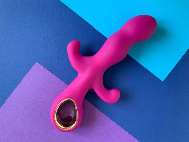 Seks oyuncağı. Mavi arka planda pembe vibratör. Yetişkinler için kullanışlı, seks dükkanı