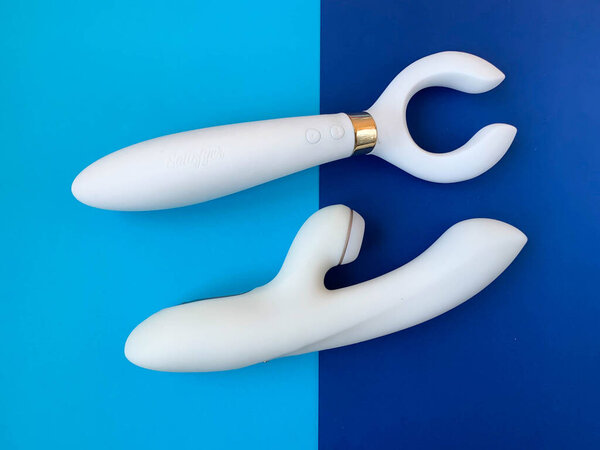 Sex toys. Two white vibrators on a blue background. Useful for adult, sex shop