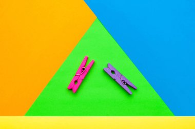 iki küçük renkli ahşap clothespin çok renkli bir arka planda