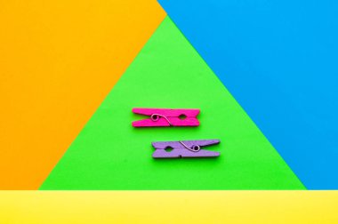 iki küçük renkli ahşap clothespin çok renkli bir arka planda