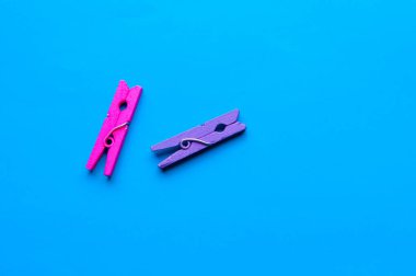 mavi arka planda iki küçük renkli ahşap clothespin