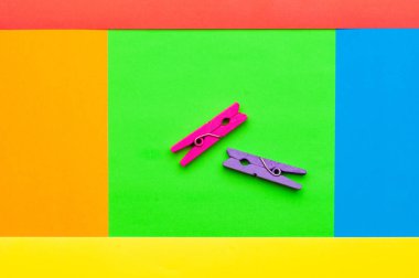 iki küçük renkli ahşap clothespin çok renkli bir arka planda