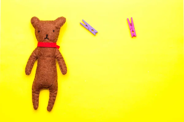 Urso de pelúcia artesanal isolado no fundo amarelo — Fotografia de Stock