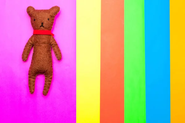 Urso de pelúcia artesanal isolado em fundo multicolorido — Fotografia de Stock