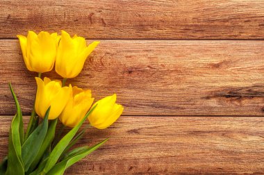 Ahşap arka planda renkli lalelerden oluşan parlak bahar buketi