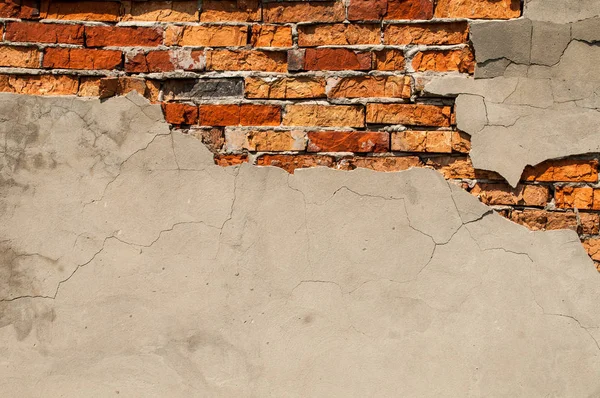 Old brick wall with fallen off plaster. Background of crack brick wall texture