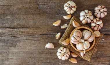 Sarmısakları kase ahşap arka plan üzerinde grup