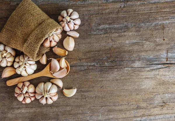 Grup sarımsak kahverengi kenevir çuval ve ahşap zemin üzerine kaşık ile