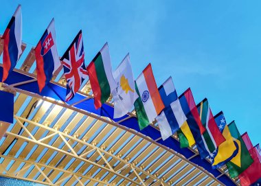 Farklı ülkelerin bayrakları günbatımı gökyüzünün arka planında