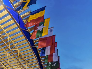 Günbatımı gökyüzünün arka planında Arap ülkelerinin bayrakları