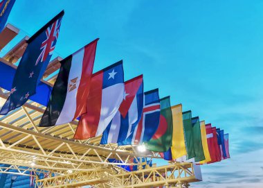 Günbatımı gökyüzünün arka planında farklı eyaletlerin bayrakları