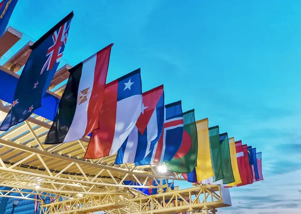 Günbatımı gökyüzünün arka planında farklı eyaletlerin bayrakları